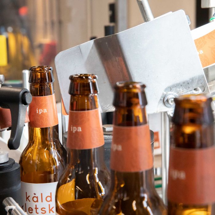Etiketten auf Bierflaschen in einer Produktionslinie, individuell bedruckbar, Signalshop.de Werbeartikel.