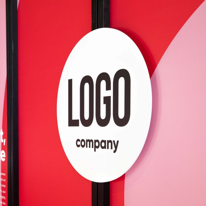 Der Inhaker® Messestand auf rotem Hintergrund, individualisierbar mit Logo, von Signalshop.de; Werbeartikel, Werbegeschenke, Werbemittel, Giveaway.
