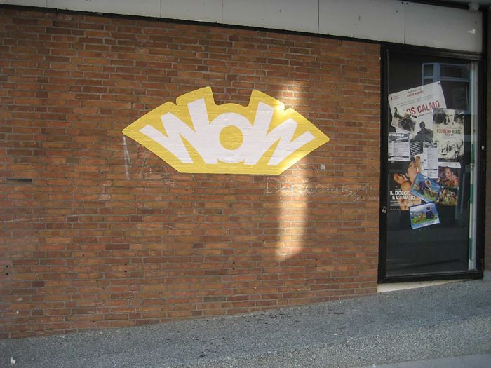 Gelber Wandaufkleber "WOW" auf roter Ziegelwand, individuell gestaltbar bei Signalshop.de, Werbeartikel.