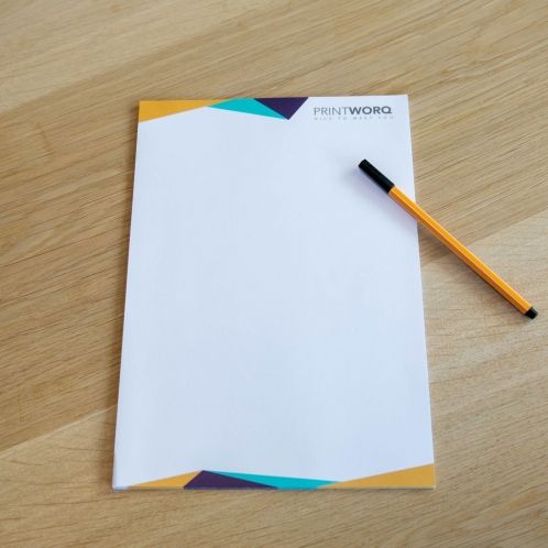 Briefpapier mit Logo auf Holzfläche, individuell gestaltbar bei Signalshop.de für Werbeartikel und Giveaways.