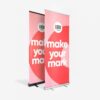 Zwei stehende Banner mit dem Text „Make Your Mark“ und einem Logo auf rosa und rotem Hintergrund.