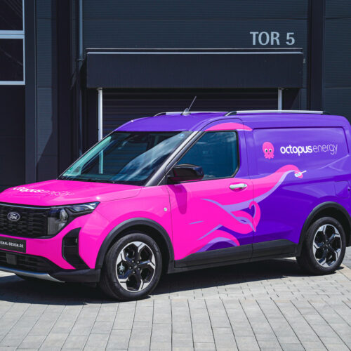 Lilafarbener Octopus Energy-Van mit Gestaltungskonzept Premium, geparkt neben einem dunklen Gebäude.