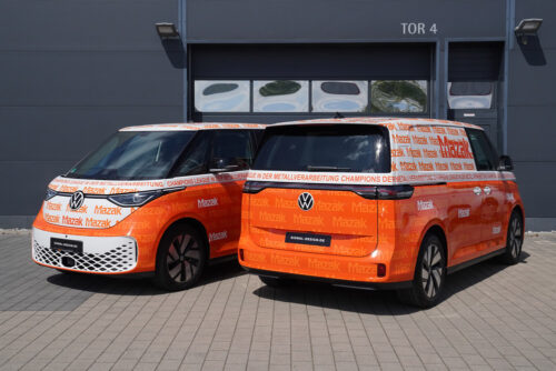 Zwei orangefarbene VW-Transporter der Marke Mazak mit individuellen Fahrzeugbeschriftungen und Gestaltungskonzept.