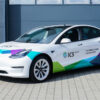 Weißes Elektroauto mit Gestaltungskonzept Premium, geparkt auf einer befestigten Fläche.