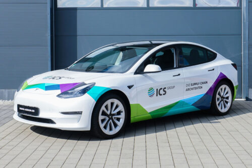 Weißes Elektroauto mit Gestaltungskonzept Premium, geparkt auf einer befestigten Fläche.