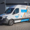 Weißer Lieferwagen mit „Seuster Labex“ und Gestaltungskonzept Premium 699€ davor geparkt.
