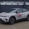 Silberner Volkswagen SUV mit Gestaltungskonzept Premium 699 €, geparkt neben einer dunklen Garage.