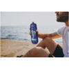 Mann sitzt am Wasser und hält eine blaue Flasche mit der Aufschrift „Healthy Life Fitness Club“.