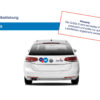 Auto mit zwei runden Aufklebern auf der Rückseite, Anleitung in Deutsch auf weißem Hintergrund.