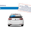 Rückansicht eines weißen Autos mit Textaufklebern auf der Heckscheibe und dem Kofferraum.